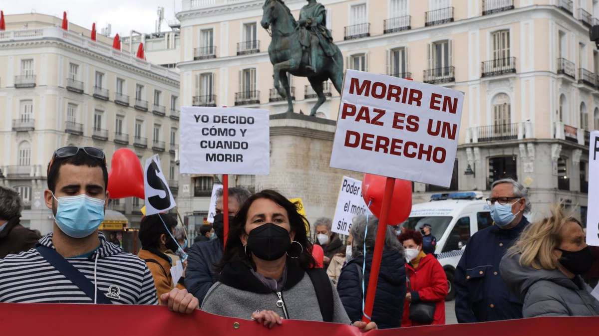 Una mujer con un cartel en el que se lee: 'Morir en paz es un derecho' durante una concentración de Derecho a Morir Dignamente en la Puerta del Sol, en Madrid (España), el 18 de marzo de 2021.