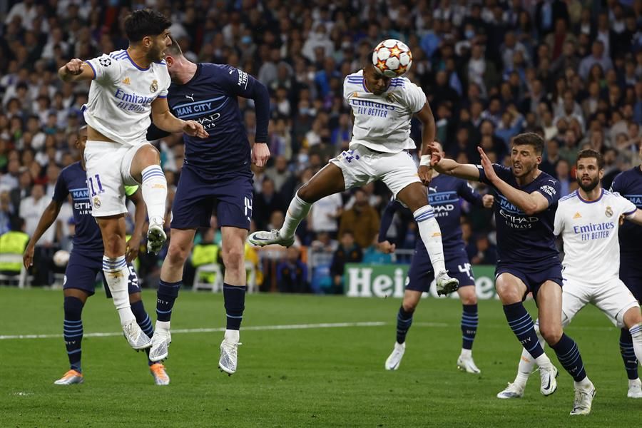 El delantero brasileño del Real Madrid, Rodrygo (3d), cabecea el balón ante el defensor del Manchester City para conseguir el segundo gol del equipo madridista
