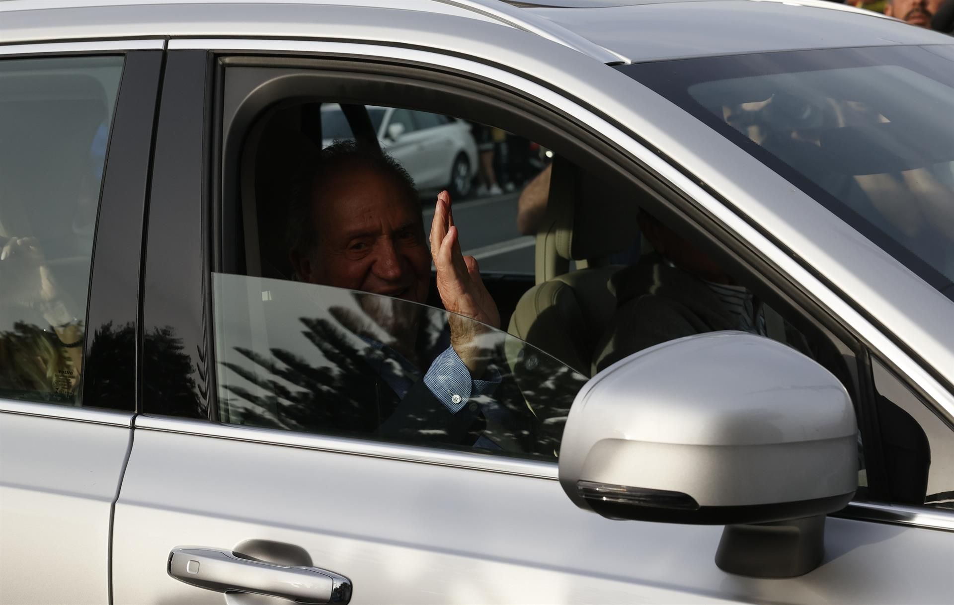 Juan Carlos I saluda tras su llegada al aeropuerto vigués de Peinador en un avión privado