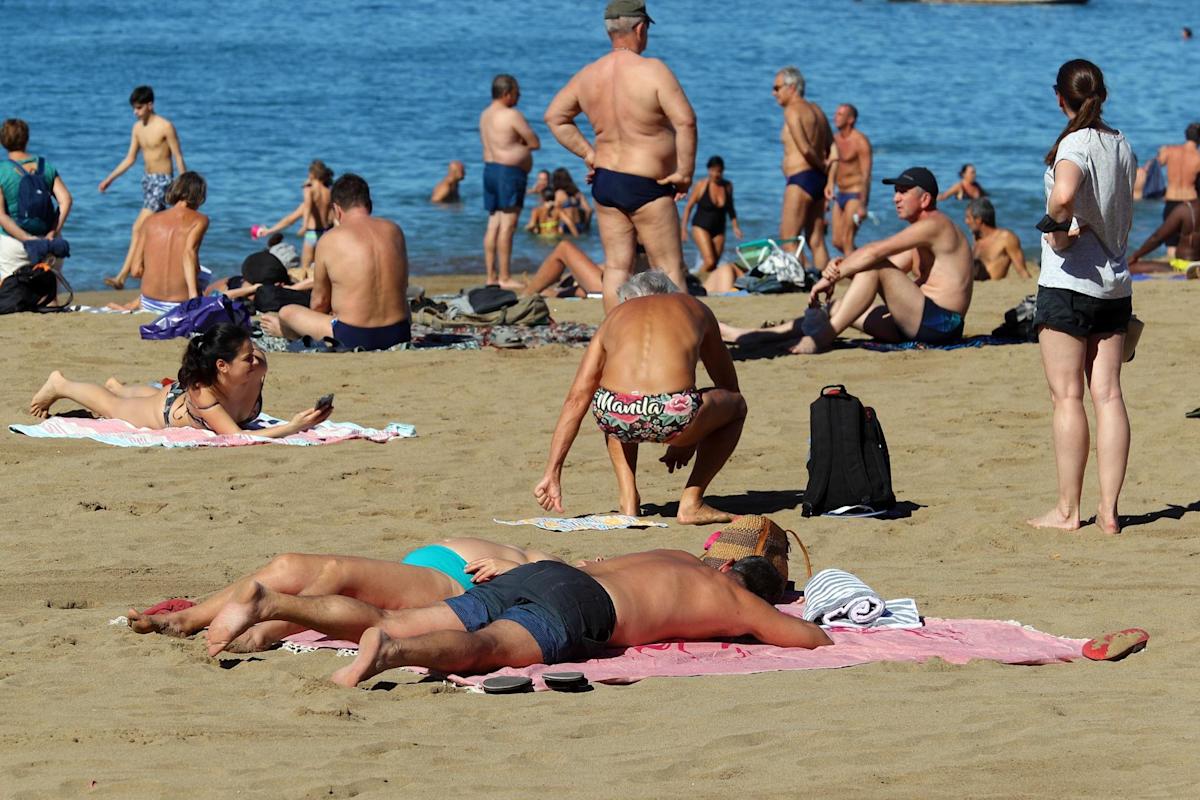 Personas tomando el sol en una playa española