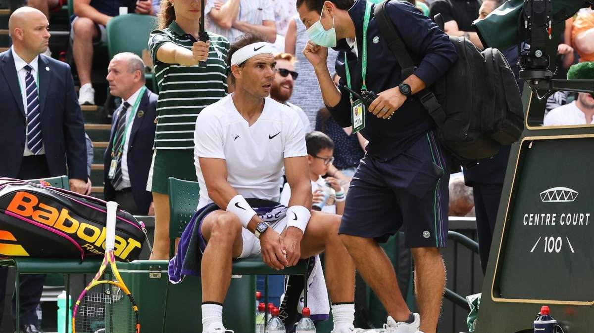 Rafa Nadal, atendido por el médico durante su partido contra Fritz en Wimbledon