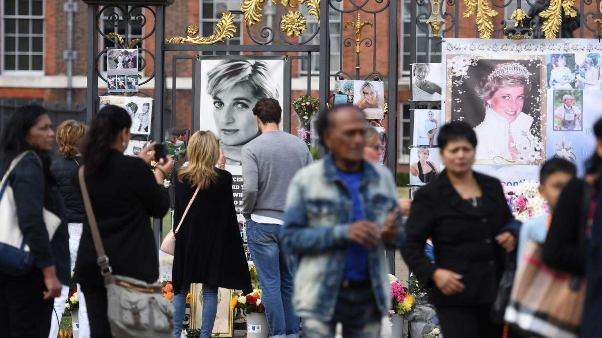 Ciudadanos depositan flores y mensajes en recuerdo de Lady Di en las afueras del Palacio de Kensington