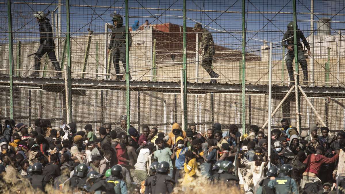 Cordon policial frente a un grupo de inmigrantes que saltaron la valla de Melilla en junio
