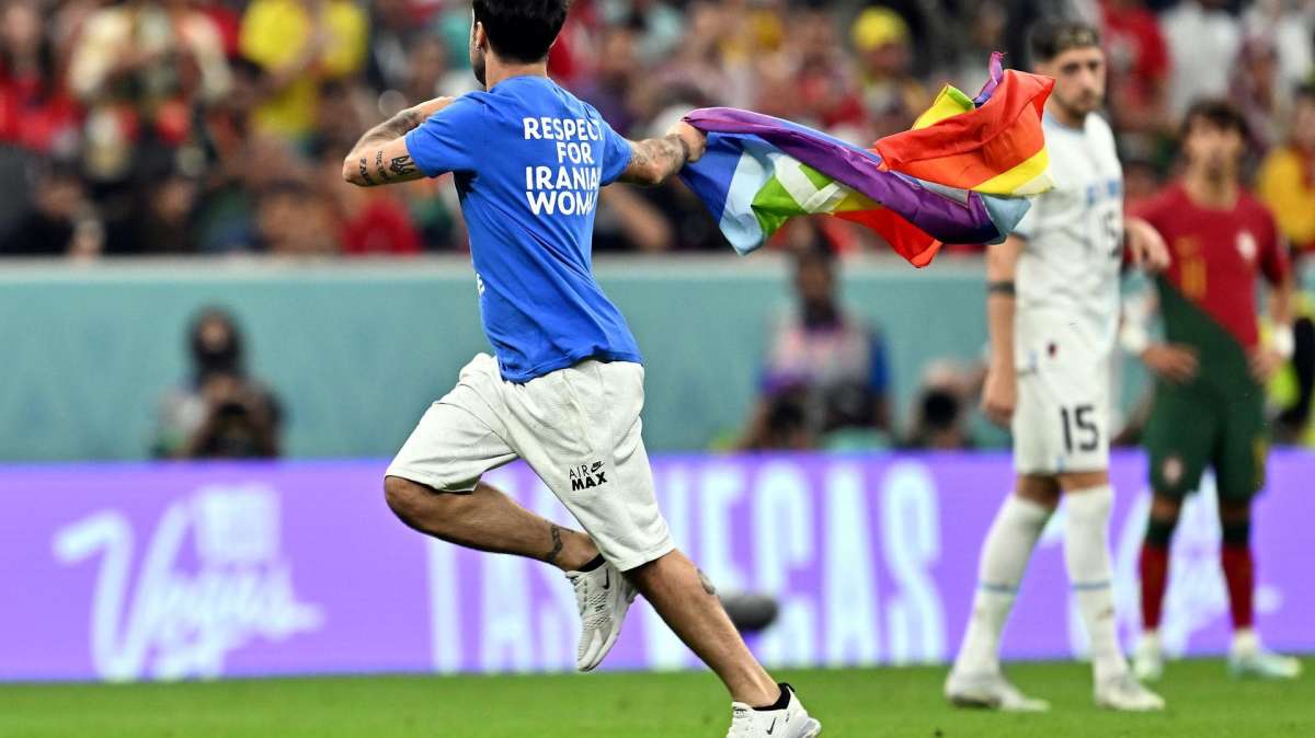 Un espontáneo salta al césped con una bandera arcoíris durante el Portugal-Uruguay