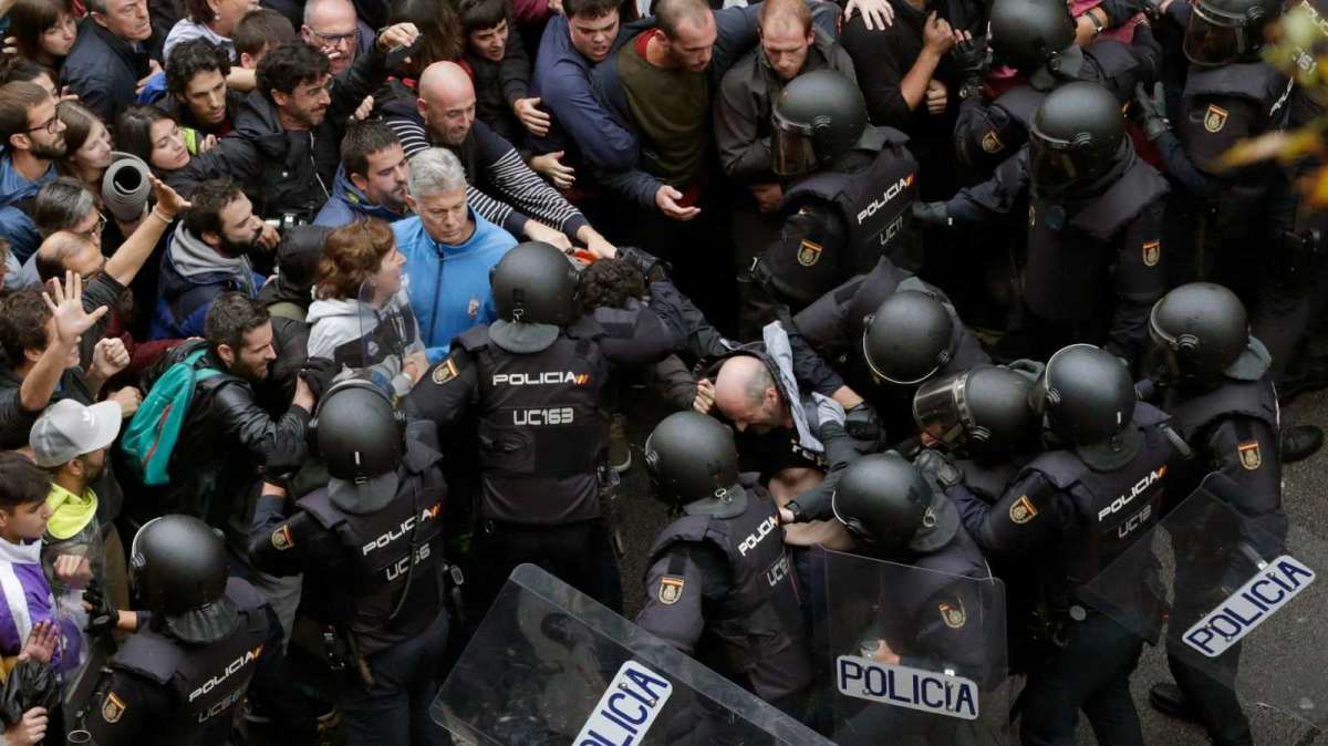 Agentes de la Policía Nacional forman un cordón de seguridad frente al colegio Ramón Llull de Barcelona durante el 1-O.