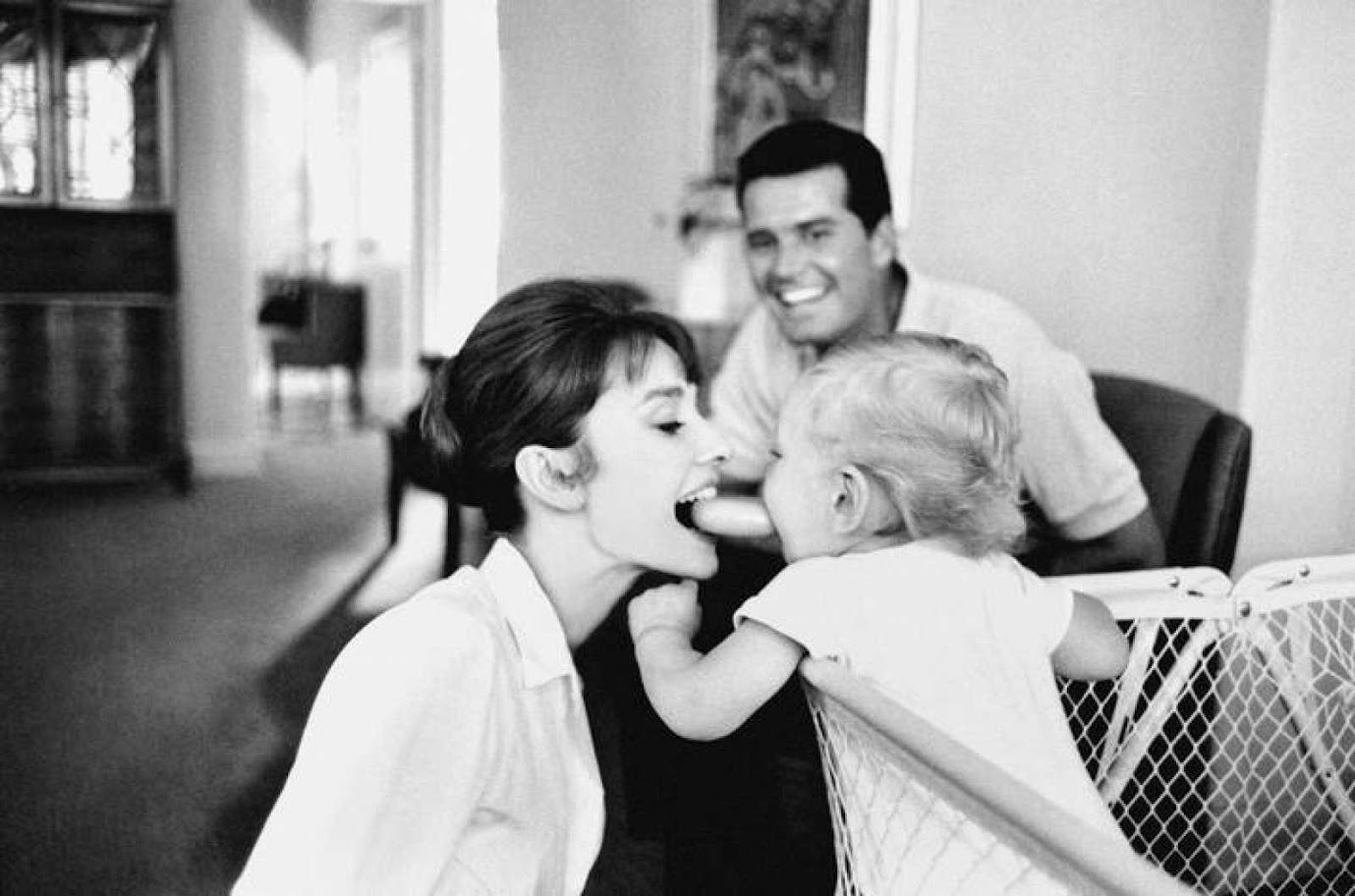 Sean, el hijo de Audrey y Mel Ferrer, juega felizmente con su madre bajo la mirada de aprobación del actor James Garner.