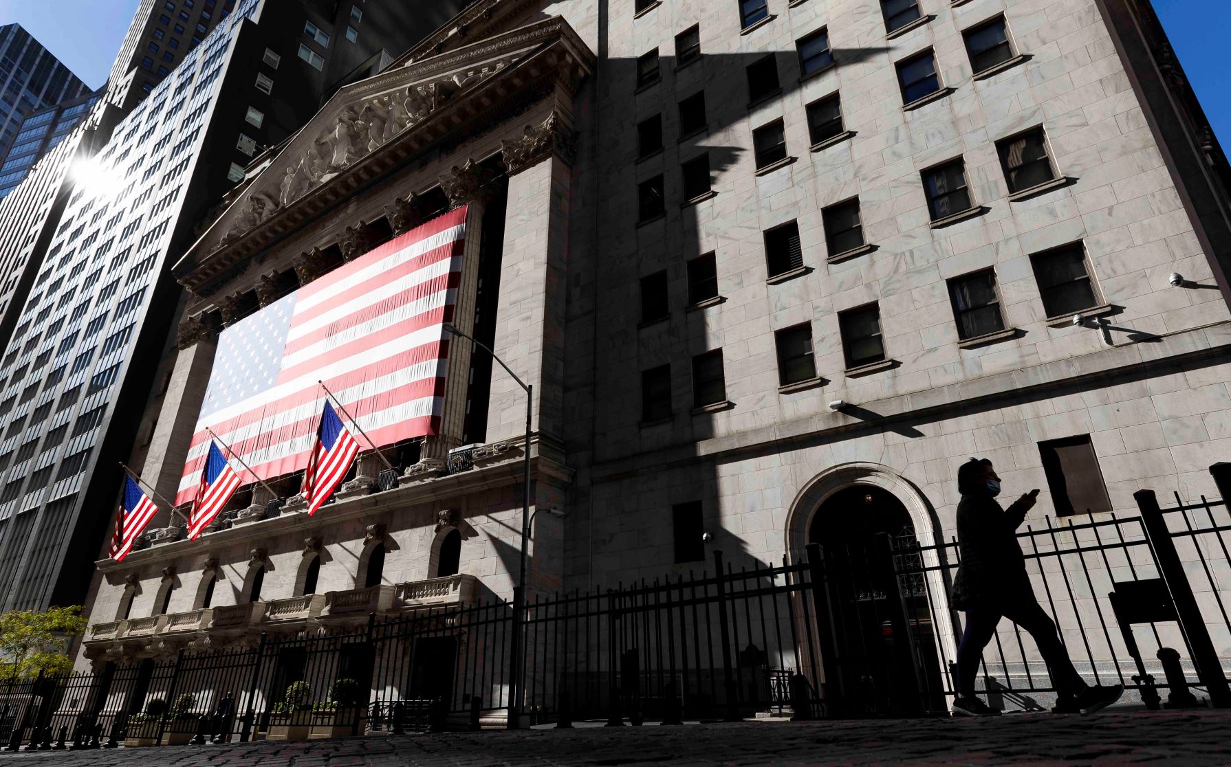 La gente pasa por la Bolsa de Valores de Nueva York en Wall Street.