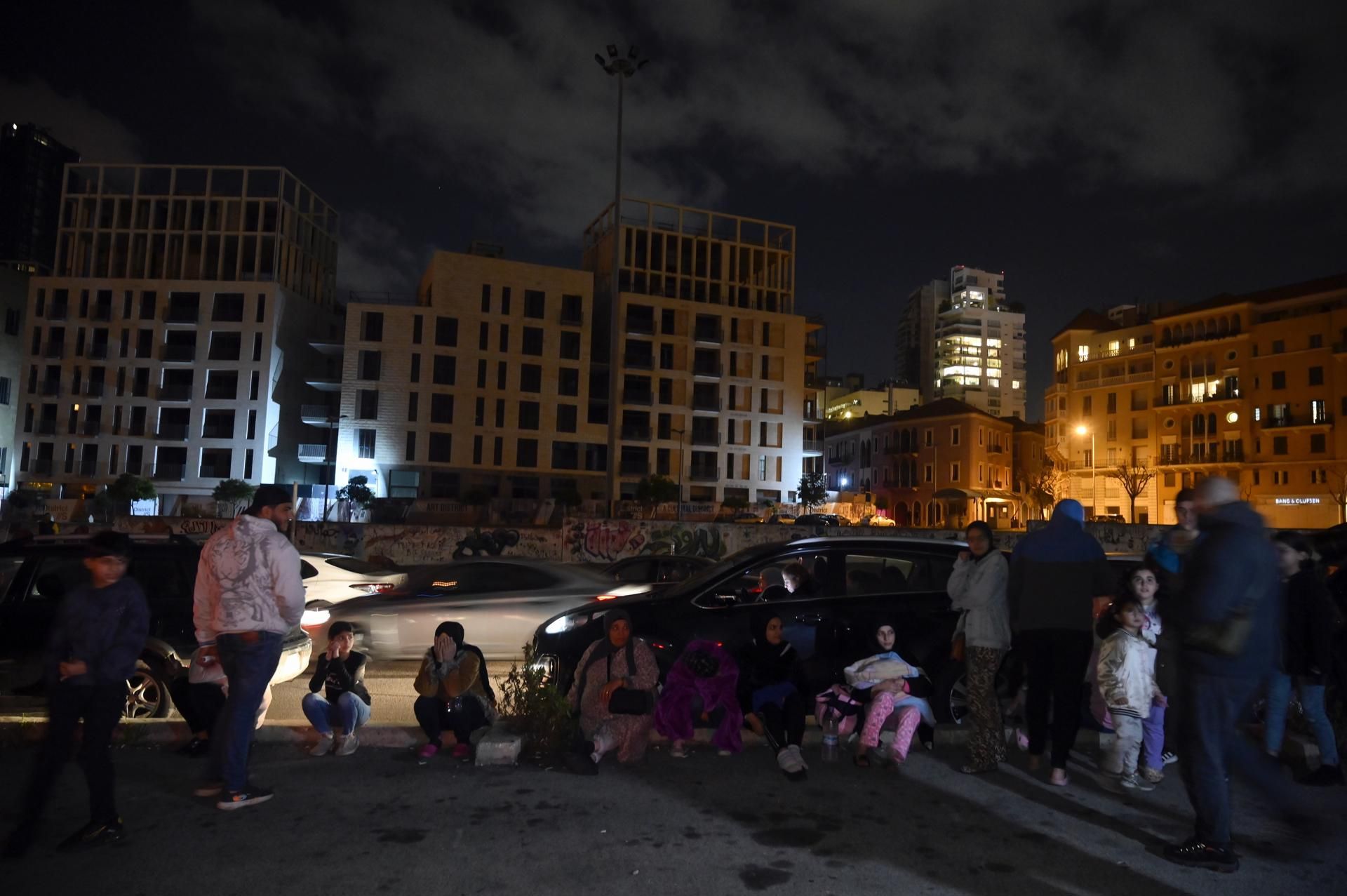 Varias personas aguardan en la calle, en el centro de Beirut, tras sentir el terremoto que ha sacudido Turquía.