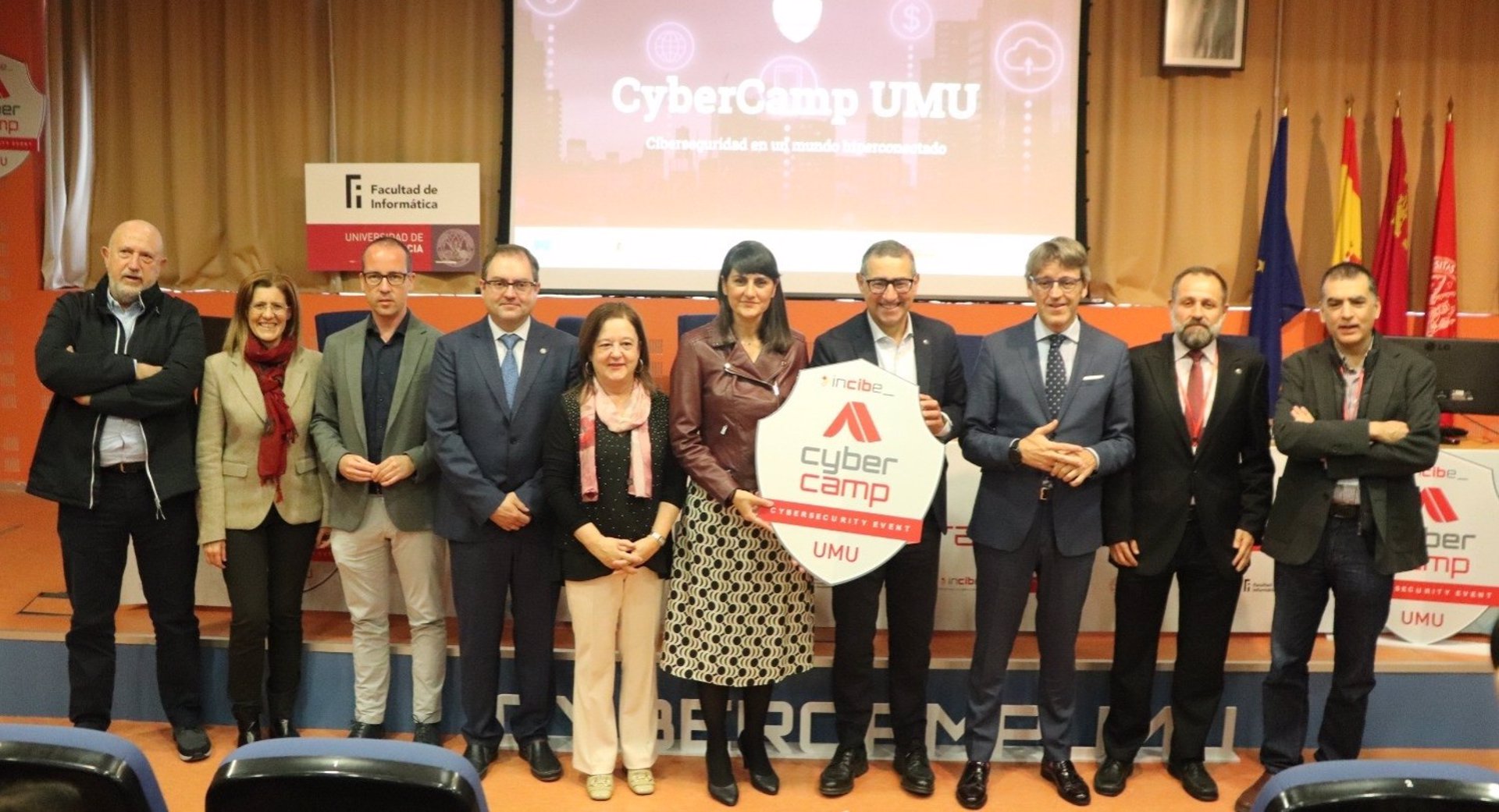 La secretaria de Estado de Telecomunicaciones e Infraestructuras Digitales, María González Veracruz (en el centro sosteniendo un logo), preside un evento en la Universidad de Murcia.