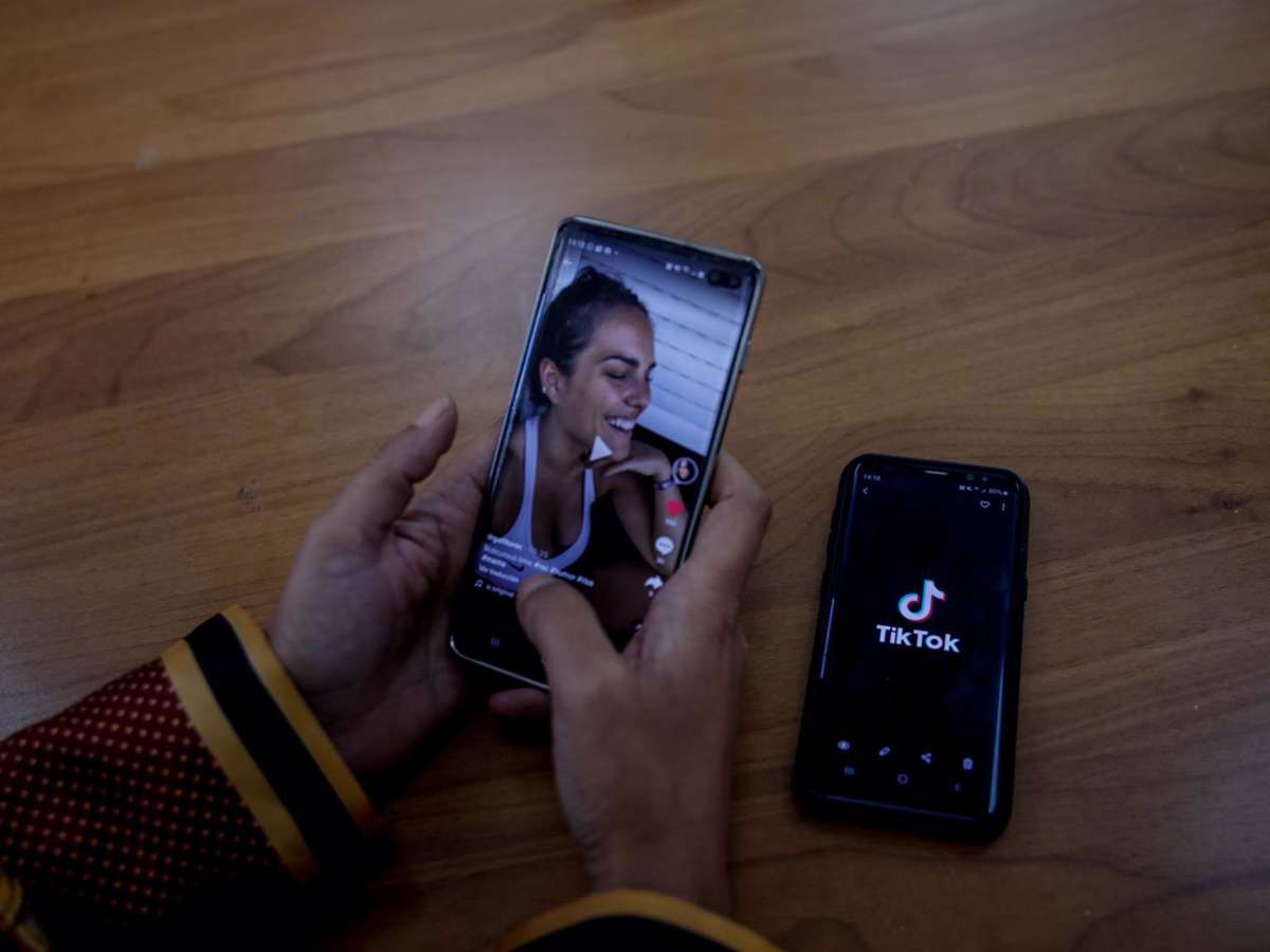 Una persona mira en su móvil el vídeo de una joven en TikTok.