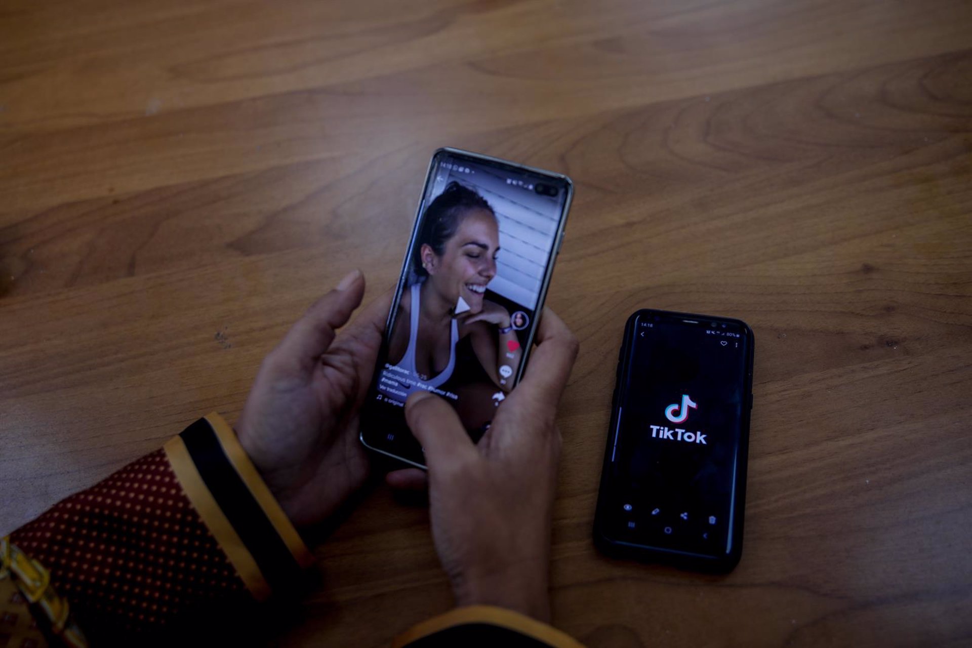 Una persona mira en su móvil el vídeo de una joven en TikTok.