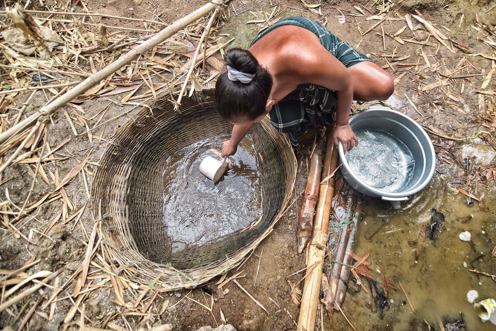 Un residente de Indonesia recoge agua de un pozo.