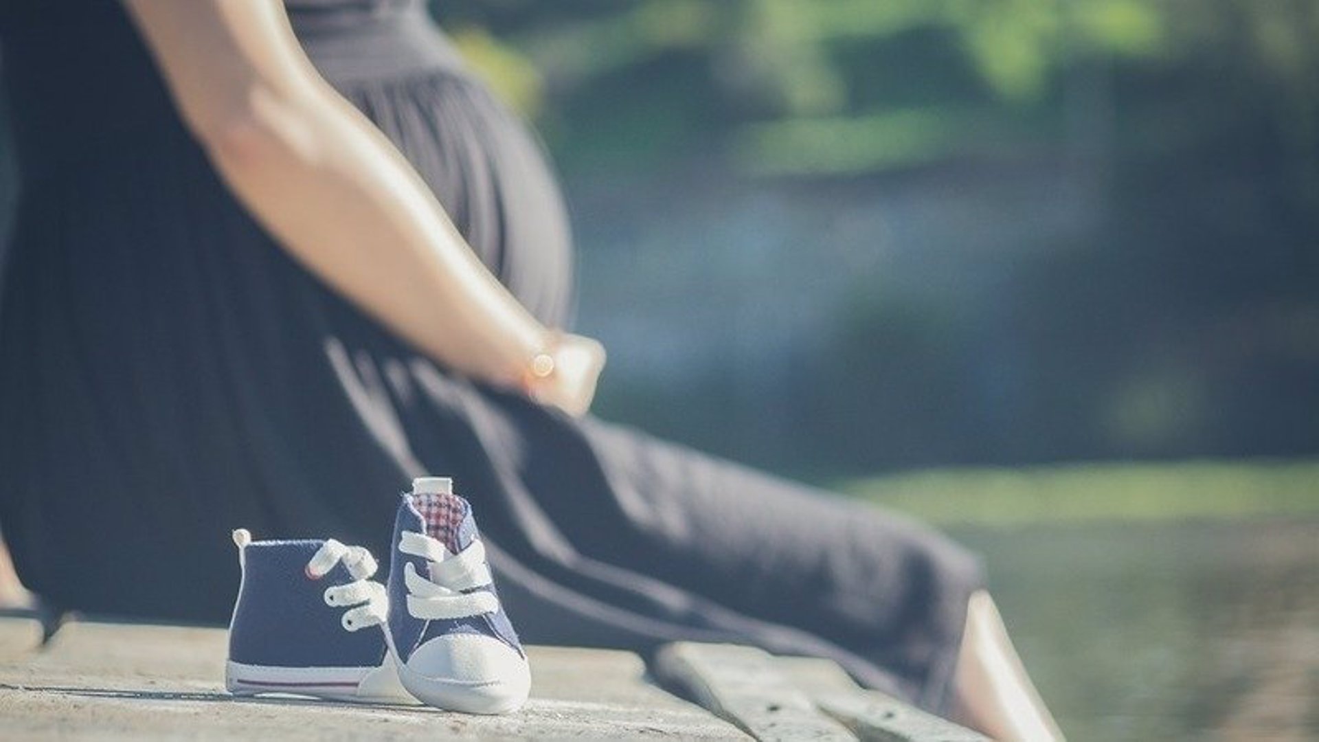 Custodia Una mujer embarazada junto a unos zapatos de bebé