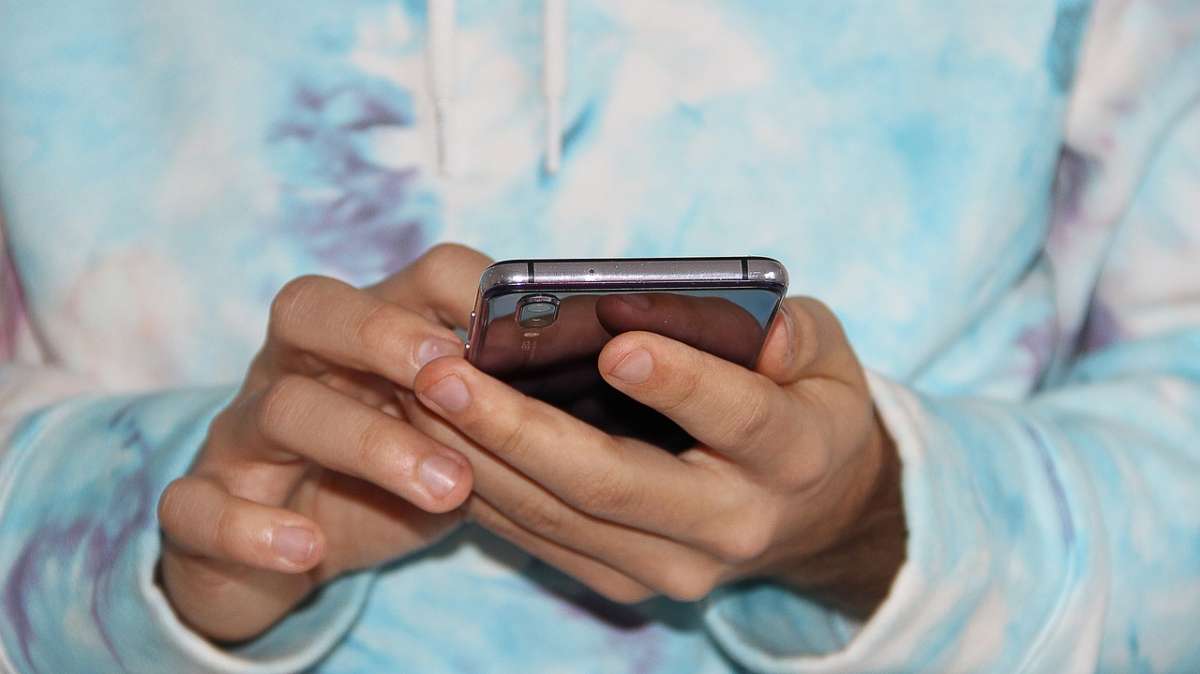 Un joven usando un teléfono móvil.