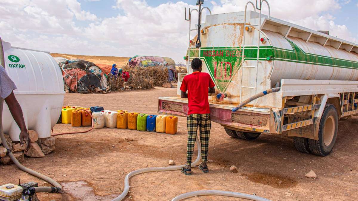 Un camionero entregando agua a las personas desplazadas en el campo de desplazados internos de Galidle, en Somalia, Africa