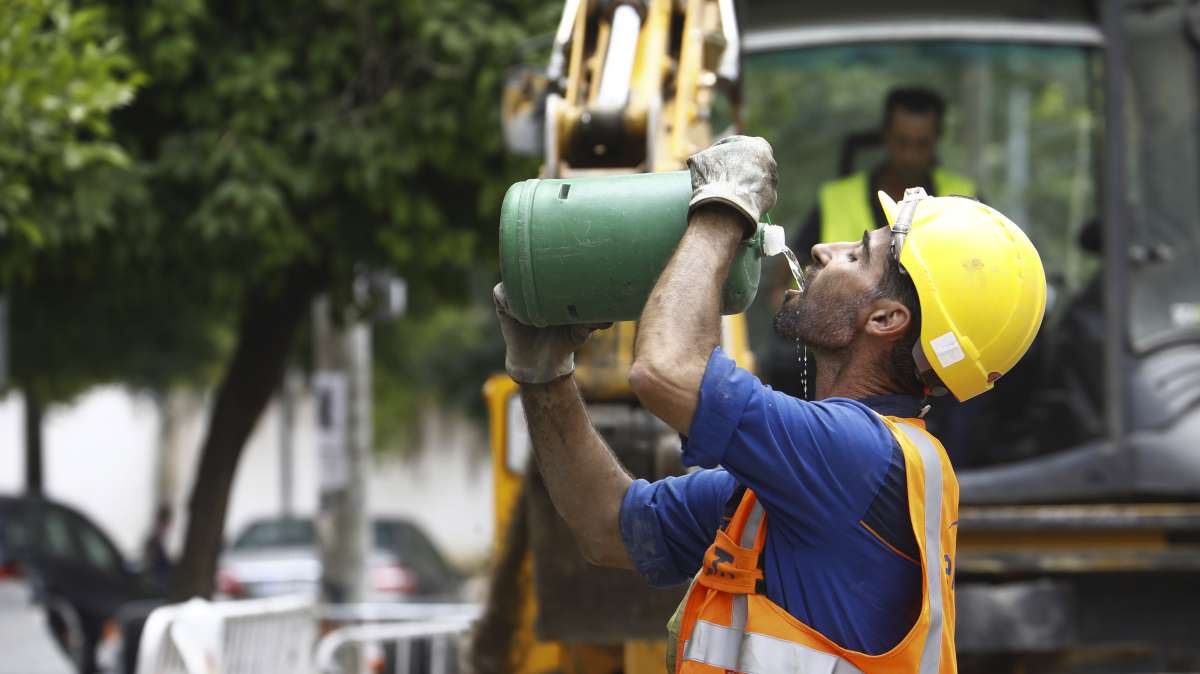 Un trabajador de la construcción bebe agua durante la jornada de trabajo en plena ola de calor.