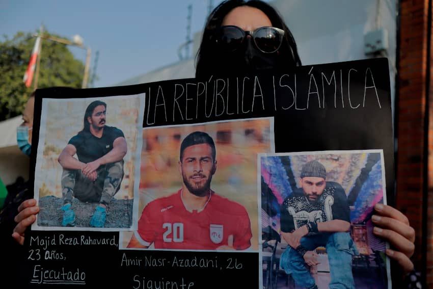 Una mujer protesta ante la embajada de Irán en México, mientras sostiene fotografías del futbolista Amir Nasr-Azadani.