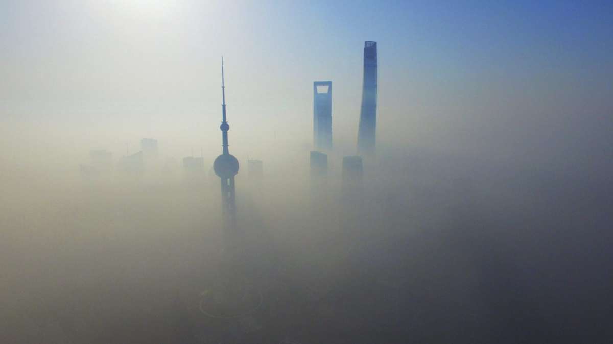 Vista aérea de los rascacielos cubiertos por una densa manta de niebla en Shanghái.