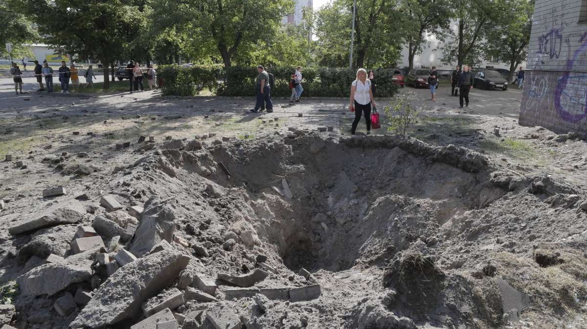Una persona junto a un cráter cerca de un edificio residencial después de un ataque de misiles en Kiev.