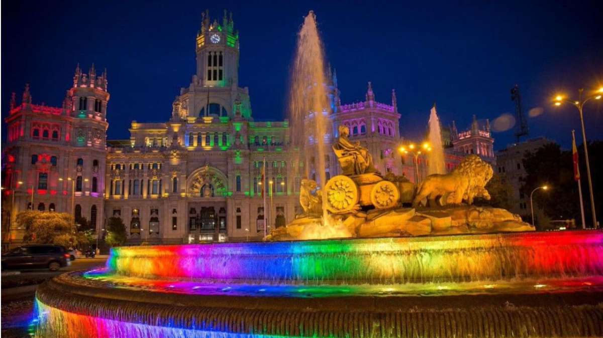 El Palacio de Cibeles y la fuente, iluminadas con los colores de la bandera LGTBI.
