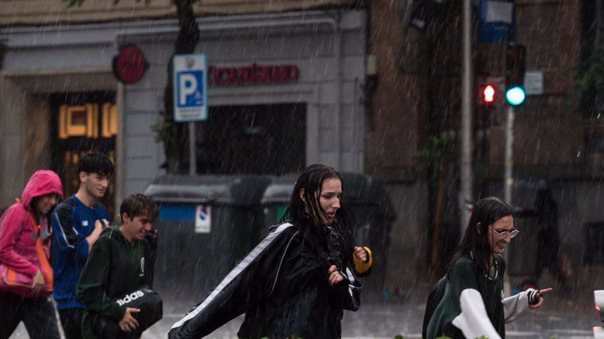 Varias personas caminan bajo la lluvia, a 29 de mayo de 2023, en Madrid.