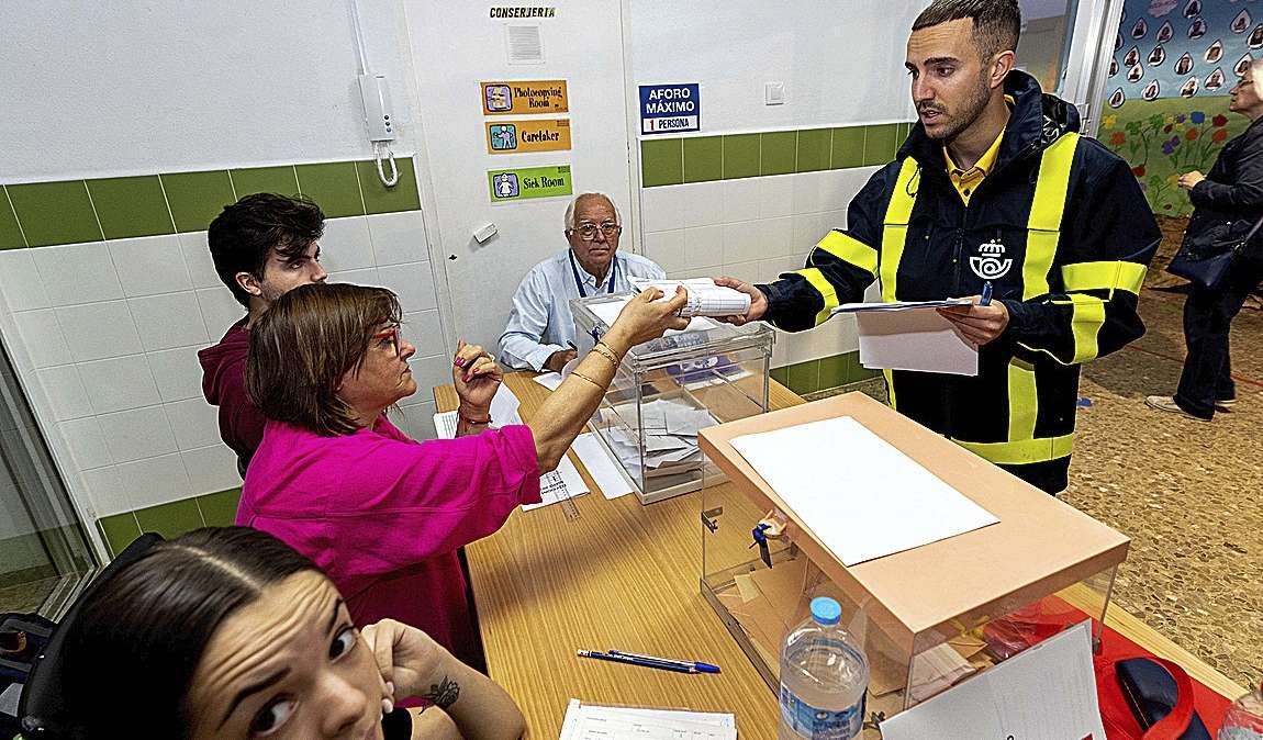 Un cartero entrega el voto por correo en una mesa electoral el pasado 28M.