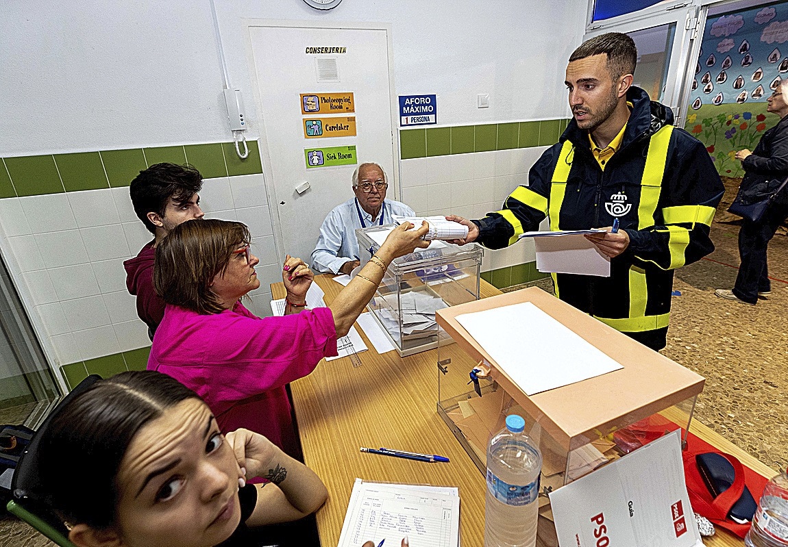 Un cartero entrega el voto por correo en una mesa electoral el pasado 28M.