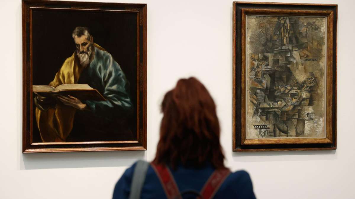Una visitante observa algunos de los cuadros que se exhiben en la exposición.
