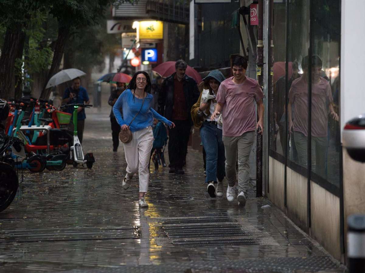 Varias personas caminan bajo la lluvia, a 29 de mayo de 2023, en Madrid (España).