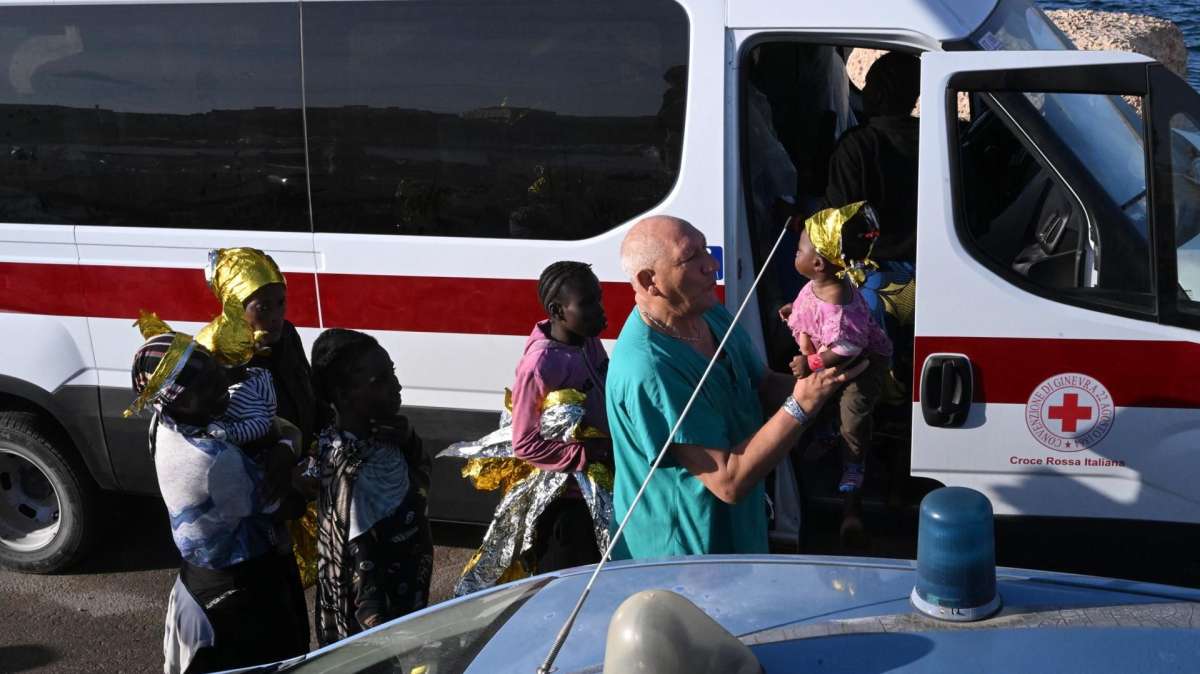 Una niña es atendida por un médico a su llegada a Lampedusa.