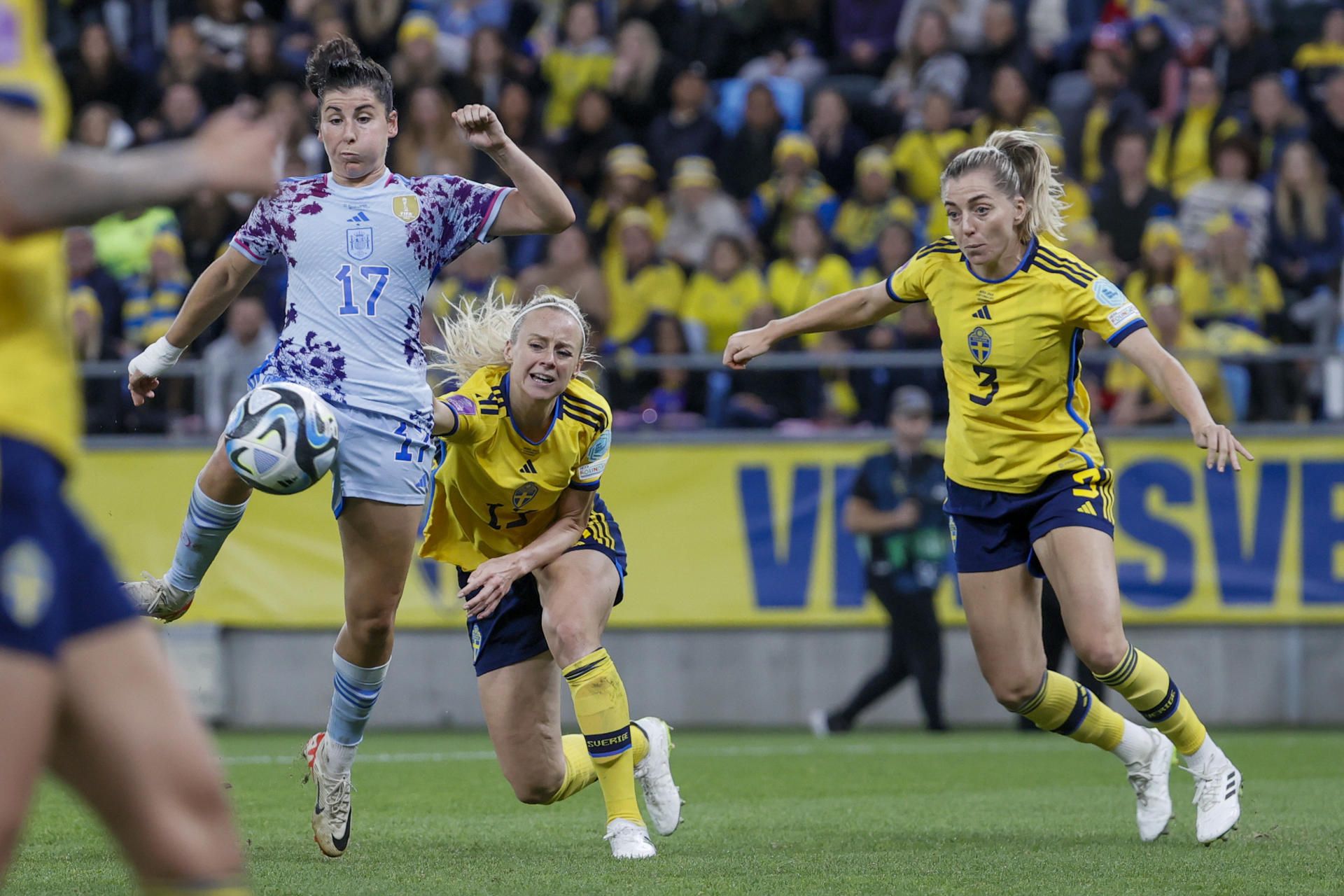 Lucía García golpea el balón ante la presencia de dos jugadoras suecas