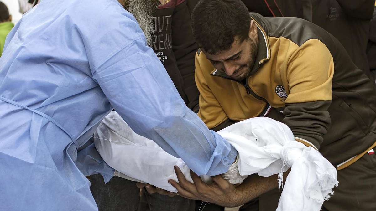 Familiares de palestinos muertos en un ataque aéreo del ejército israelí en Gaza trasladan un cadáver.