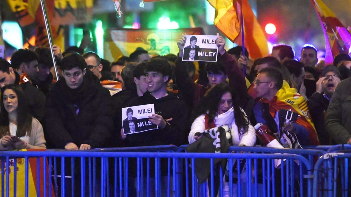 Varias personas portan banderas españolas y carteles del Presidente argentino, Javier Milei